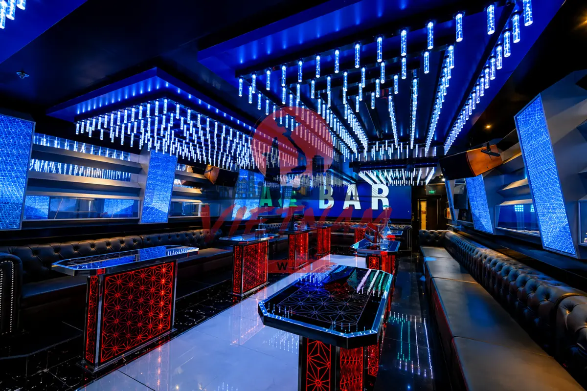 나트랑 퀸터 가라오케 버티컬 블루 네온 파티 룸 — 버티컬 블루 천장 조명과 ALE BAR LED 비전 아트월 및 블랙 롱 소파
